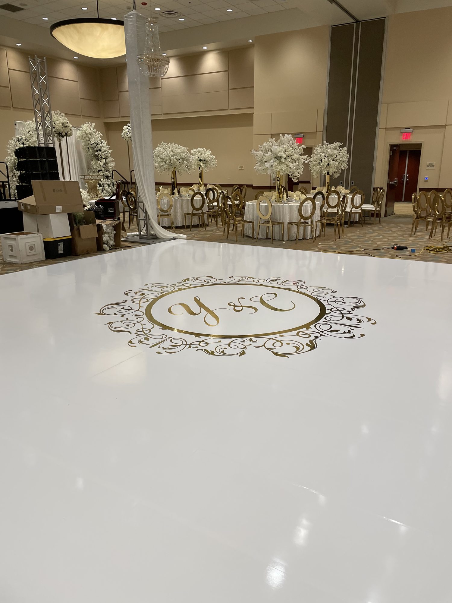 Gold monogram decal applied over a white gloss vinyl dance floor at a wedding
